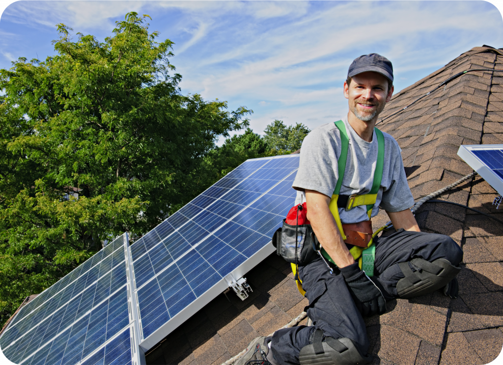 Mann auf Dach neben Solaranlage bei gutem Wetter